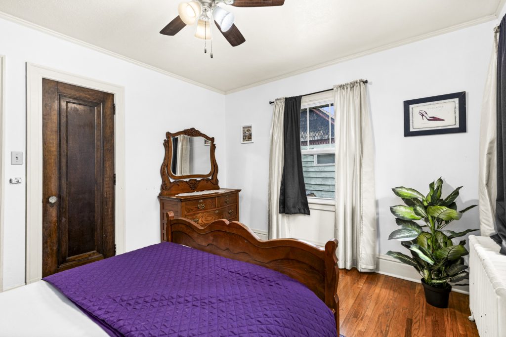 Antique vanity dresser and a bright window in the purple room.