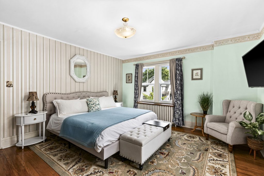 Sitting chair and full length mirror round out the bedroom.