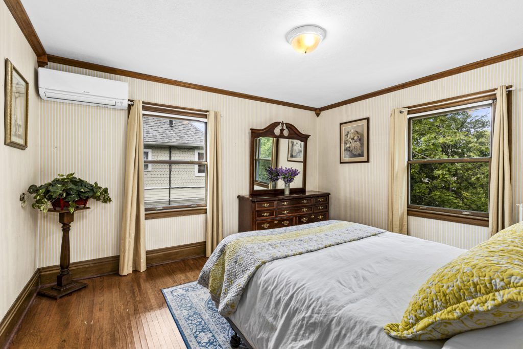 Corner windows, AC unit, and a comfortable queen bed.