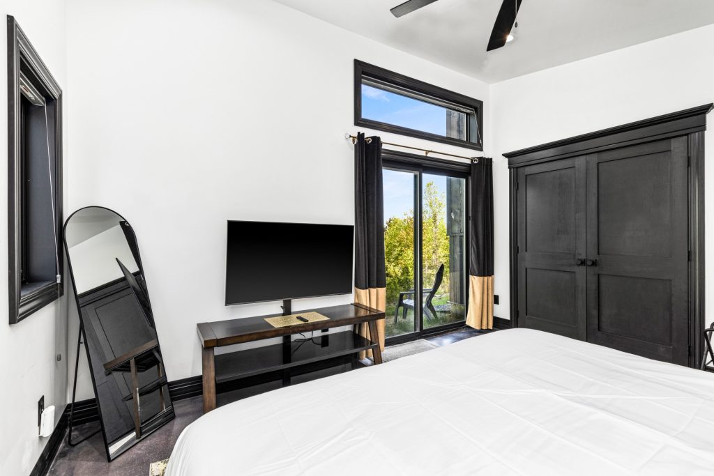 The large master bedroom features a king bed and outdoor access.