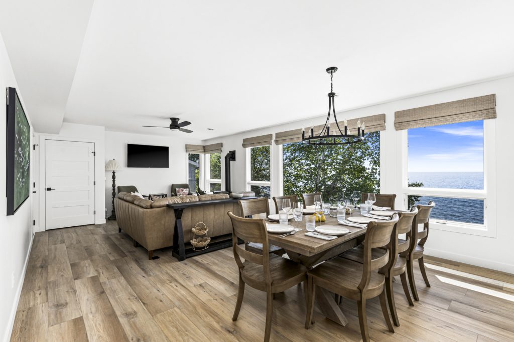 The open concept living and dining area invites everyone together, all framed by panoramic lake views.