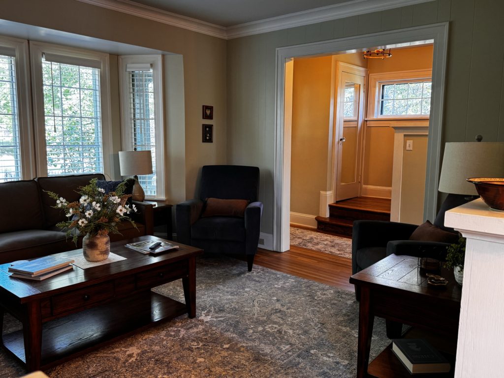 Living room with front entryway and stairs to upstairs in the background.