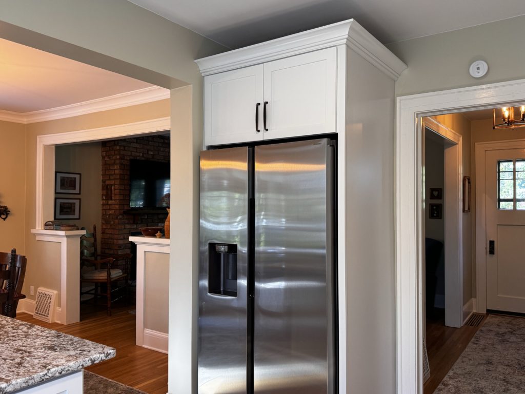 Kitchen fridge center, entryway to right, and dining & living room to the left.