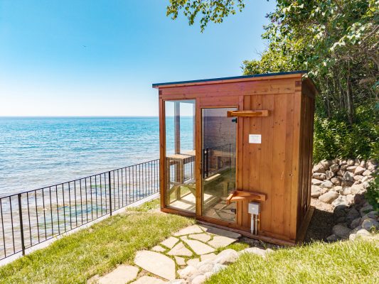 A private cedar sauna sits at the water's edge, ready to melt away the day right along the shoreline.