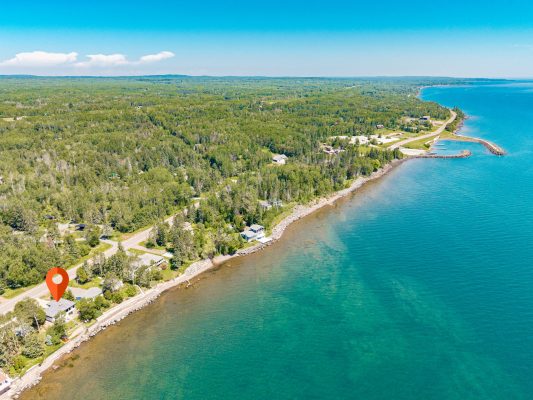 An aerial view captures the property's rare setting just down the road from McQuade Small Craft Harbor.