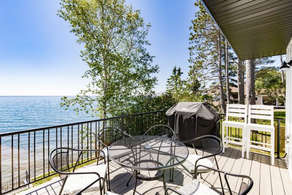 Sip your morning coffee on the private deck, surrounded by mature trees and the endless blue of the lake.