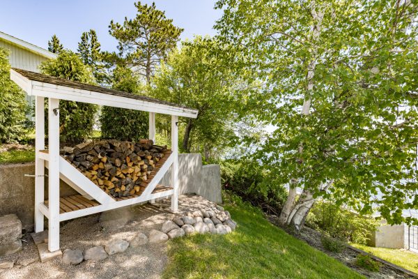 Neatly stacked firewood sits ready under cover, perfect for cozy nights by the fire.