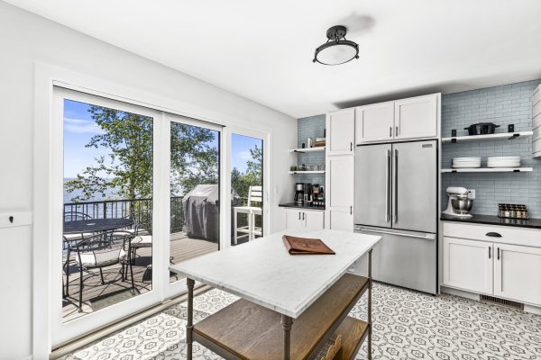 The bright, modern kitchen features stainless appliances, a center island, and easy access to the lakeside deck.
