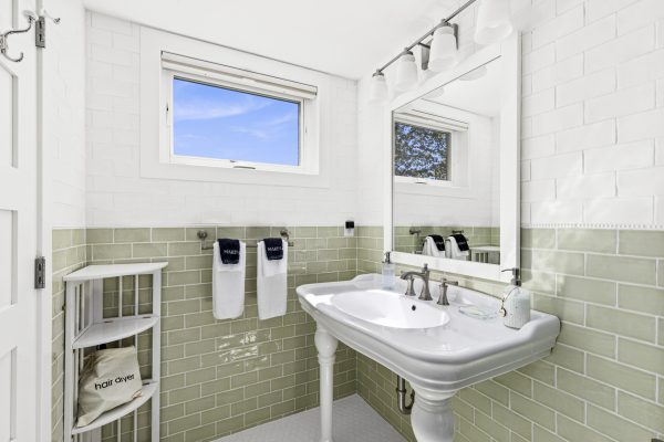 The green bedroom's private ensuite shines with classic green tile and a bright, airy feel.