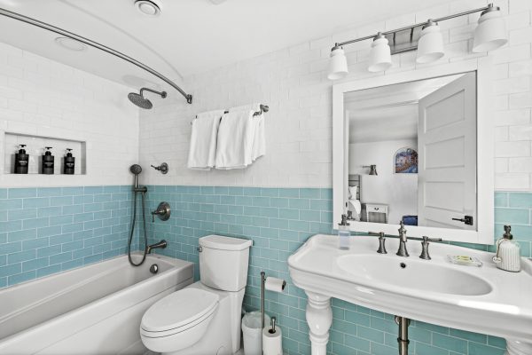 The ensuite's pedestal sink and aqua tile bring timeless lakeside charm to your daily routine.